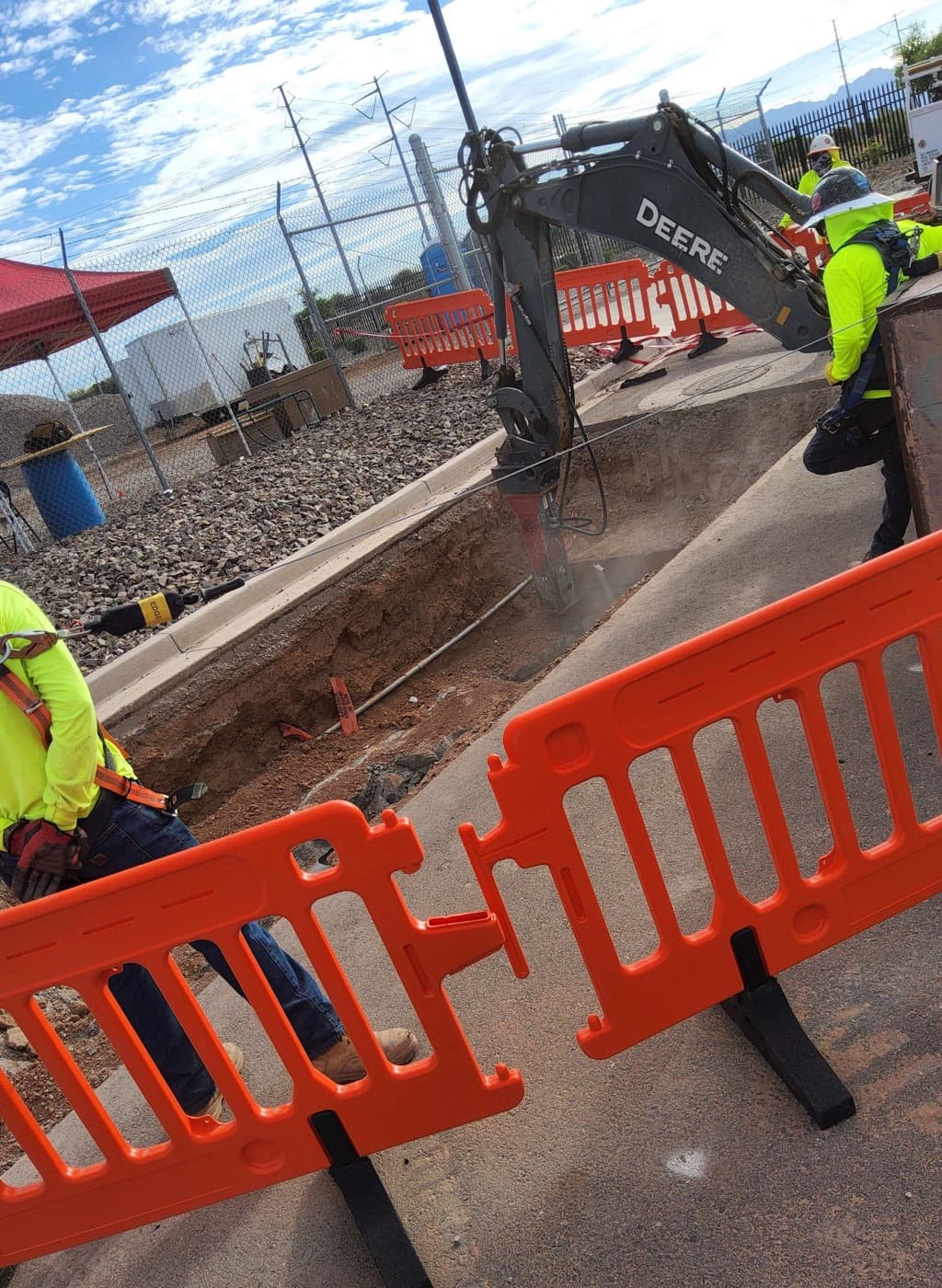 EarthTech crew working a trench behind safety barricades